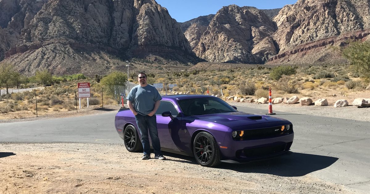 Andy standing in nature next to a car