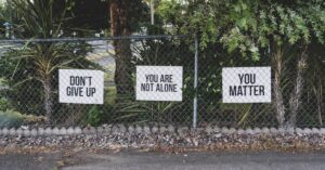 Signs that say You matter, Don't give up, and you are not aone