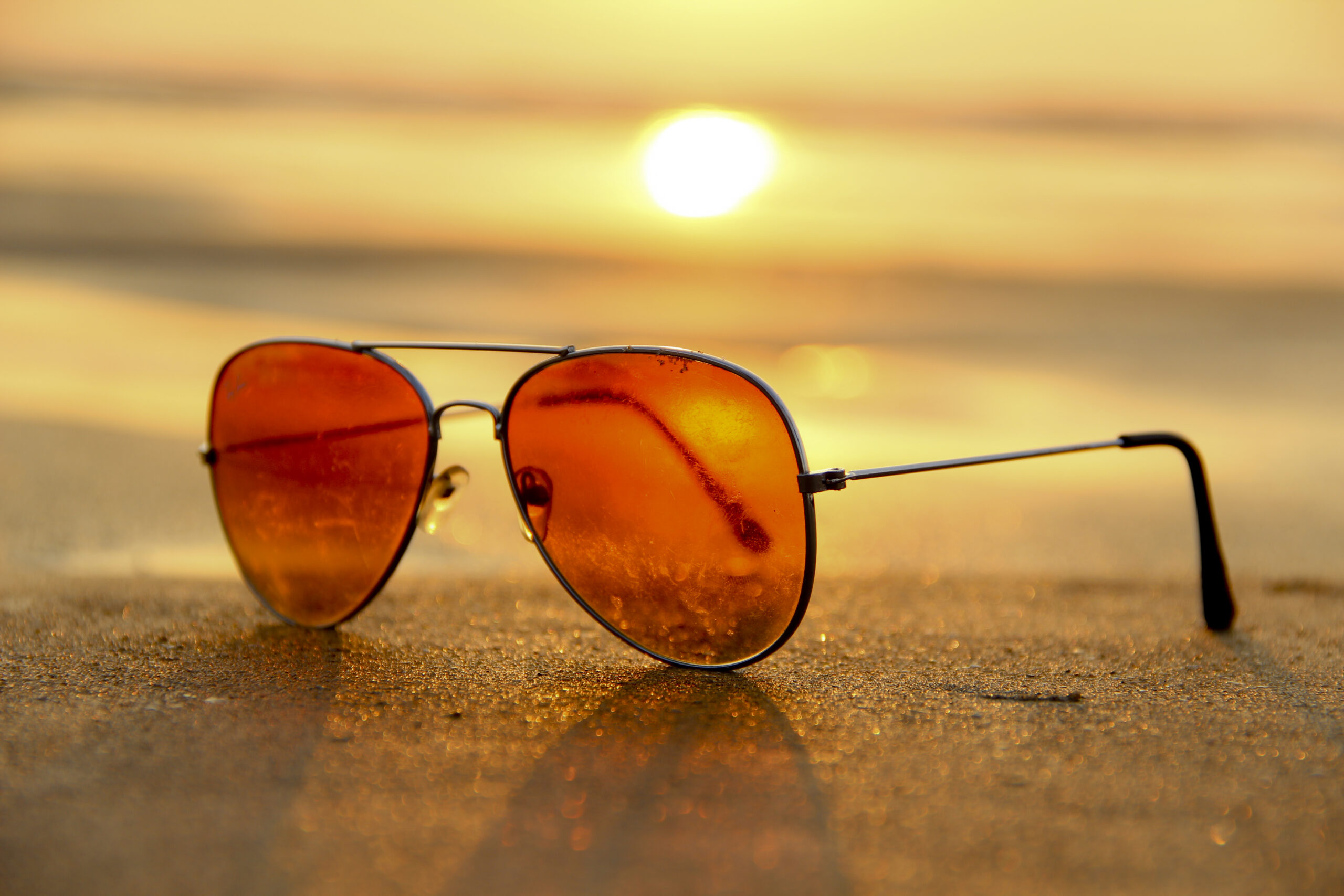 Sunglasses on a beach at sunset